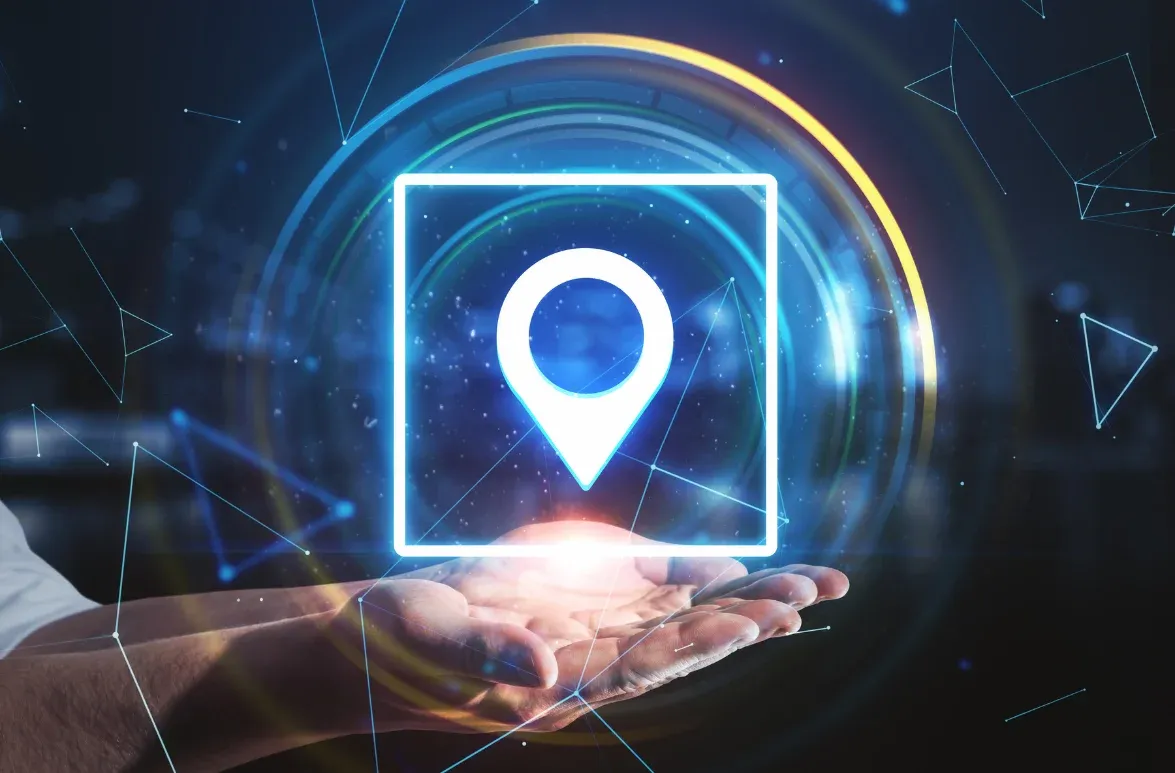 A futuristic image of a hand holding a glowing location pin, symbolising GPS tracking and telematics technology for fleet management.